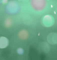 Blurred circles of light, colored balls, glowing drops on a calm translucent green background. Fuzzy air abstract background