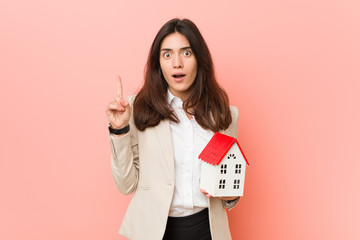 Young caucasian woman holding a house icon