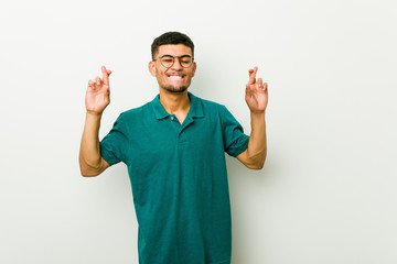 Young hispanic man crossing fingers for having luck