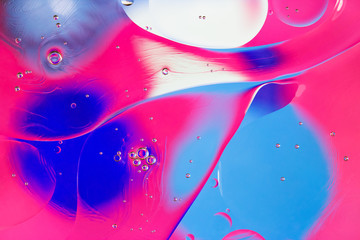 Colorful abstract background. Pink blue white circles and oil bubbles in the water closeup. Macro...