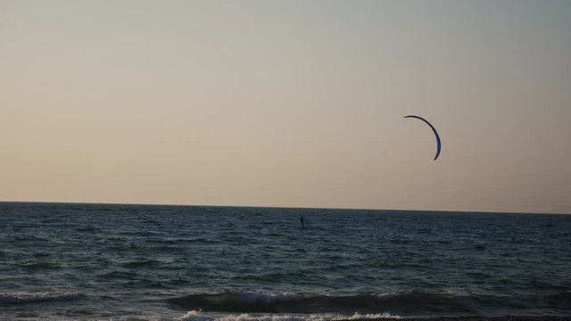 Kyte surfer on the sea waves at dusk