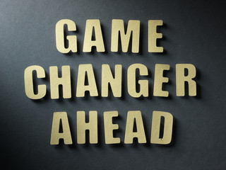 The word Game Changer Ahead on paper background