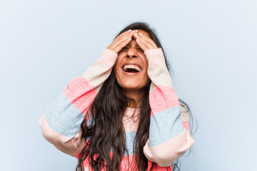 Young fashion indian woman covers eyes with hands, smiles broadly waiting for a surprise.