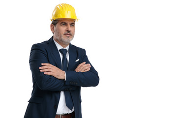 Businessman wearing a saftey hat and holding his hand crossed