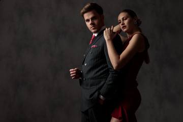 man with hand in pocket and woman holding his shoulder