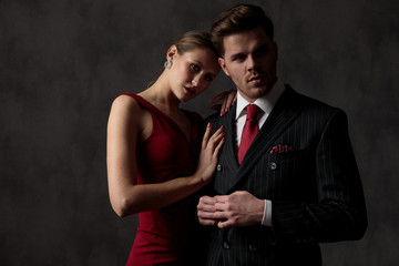 man fixing button and woman embracing him