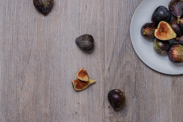 Higos ecológicos sobre plato gris y fondo de madera
