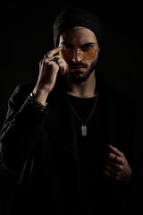 hipster guy adjusting his orange sunglasses