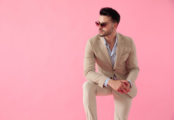 attractive young man wearing a suit and a pair of sunglasses