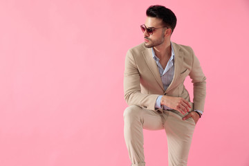 smart casual young man wearing a suit and sunglasses