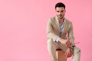 attractive young man holding a pair of sunglasses