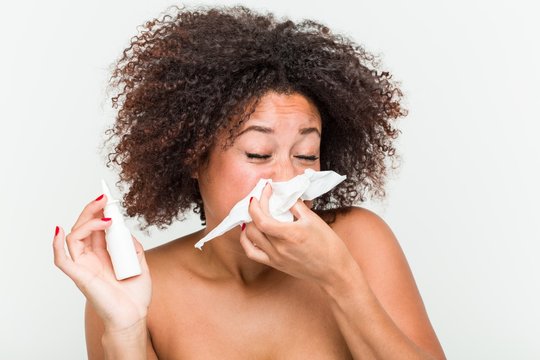 Close up of a young african american woman using a nasal spray