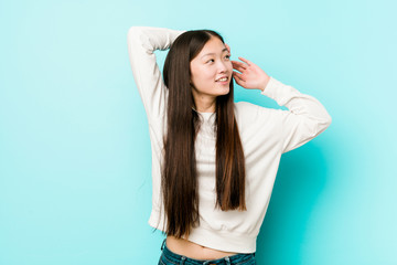 Fototapeta premium Young pretty chinese woman stretching arms, relaxed position.