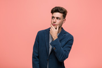 Young business natural man looking sideways with doubtful and skeptical expression.