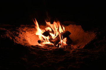 brennendes Lagerfeuer in einer Sandkuhle an einem Strand in Dänemark, Bornholm