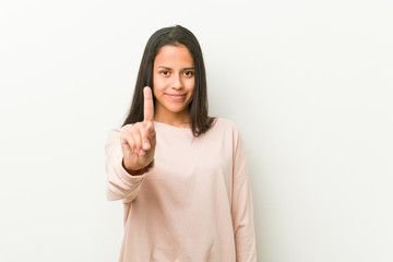 Young cute hispanic teenager woman showing number one with finger.