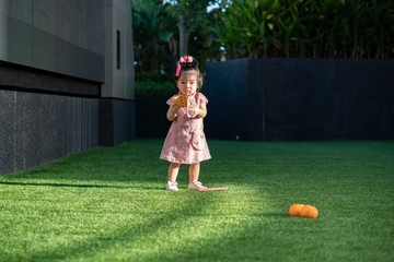 Cute little asian baby girl wearing cheongsam holding red packet, ang pow. Chinese new year...