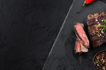 fried steak with sliced pieces on black plate 
