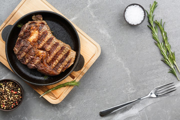 fried steak in pan on gray marble table top view