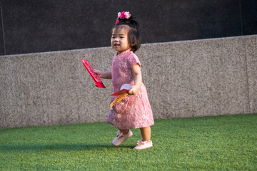 Cute little asian baby girl wearing cheongsam holding red packet, ang pow. Chinese new year...