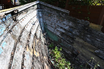 A weathered, and very old wooden rowing boat nearby the harbor of  Szczecin Lagoon.