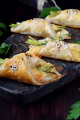 Green asparagus and cheese puff pastry folded as envelope and topped with sesame seeds