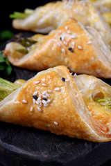 Green asparagus and cheese puff pastry folded as envelope and topped with sesame seeds