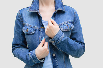 Caucasian girl in a blue denim jacket close-up on a gray background.