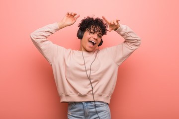 Young african american woman with a birthmark dancing and listening to music with a headphone