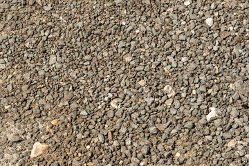 Trampled fine gravel on a walkway near the riverbank. Background.