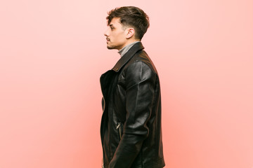 Young hispanic man wearing a leather jacket gazing left, sideways pose.