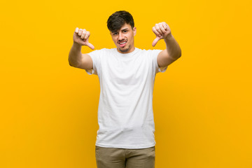 Fototapeta premium Young hispanic casual man showing thumb down and expressing dislike.