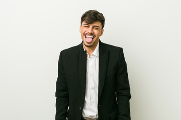 Young business hispanic man funny and friendly sticking out tongue.