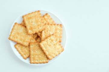 Cracker cookies on a white saucer. White background. View from above.