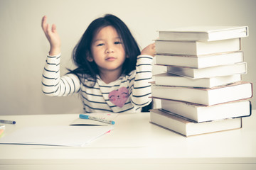 Blurred soft image of A 6 year old Asian girl, Are falling asleep While doing homework, on white table with white wall background, Concept to children and education.