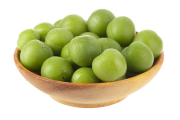 heap green cherry-plum in wooden plate isolated on white background
