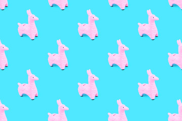 Pink zine type toy alpaca llama on blue background close up, coin money bank. Creative and fun trendy collage of funky animal saving for travel concept banner with copy space