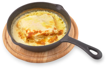 Traditional Italian dish, chicken Lasagna in a cast iron pan on a wooden board. Isolated on White Background