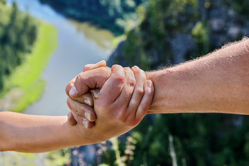 Helping hand extended to girlfriend during hiking.