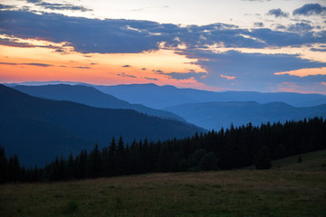 Fototapeta na wymiar red-blue sunset haze in the mountain gorge, orange-blue sunset in the mountains
