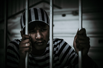 A man desperate to catch the iron prison,prisoner concept,thailand people,Hope to be free.