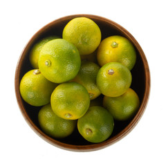 fresh limequat  in wooden plate isolated on white background
