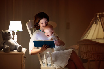 Mother reading a book to little baby