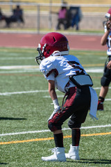 Defensive youth football player reads the field and is ready for the next play.