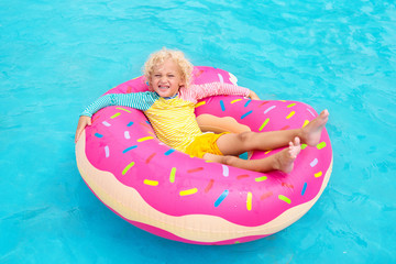 Child in swimming pool on donut float