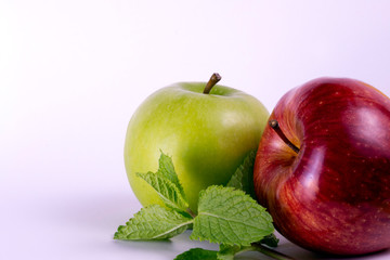 Red and green apples on white background, mint leaves, ripe apples