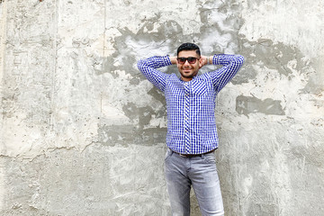 Portrait of happy successful handsome bearded young man in checkered blue shirt and sunglasses...