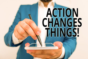 Conceptual hand writing showing Action Changes Things. Concept meaning start doing something against problem resolve or achieve it Businessman in blue suite with laptop pointing with finger