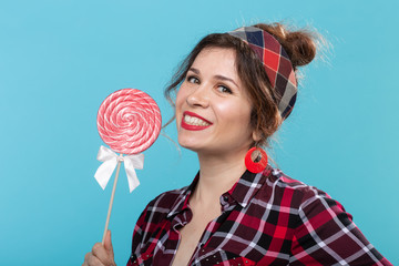 pin-up woman, fashion, people concept - woman in pin-up style with lollipop