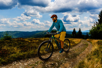 Cycling man riding on bike at sunset mountains forest landscape. Cycling MTB enduro flow trail track. Outdoor sport activity.